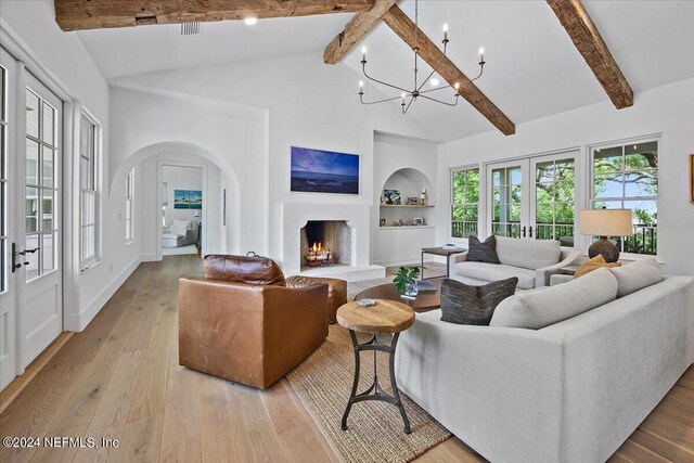 living room with built in shelves, a chandelier, high vaulted ceiling, beam ceiling, and light hardwood / wood-style floors