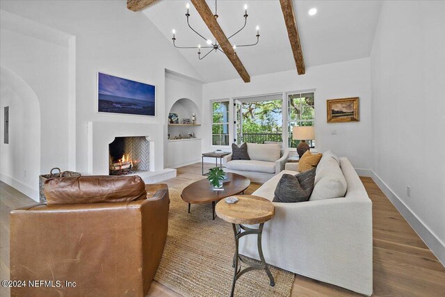 living room featuring hardwood / wood-style floors, high vaulted ceiling, built in shelves, beamed ceiling, and a chandelier