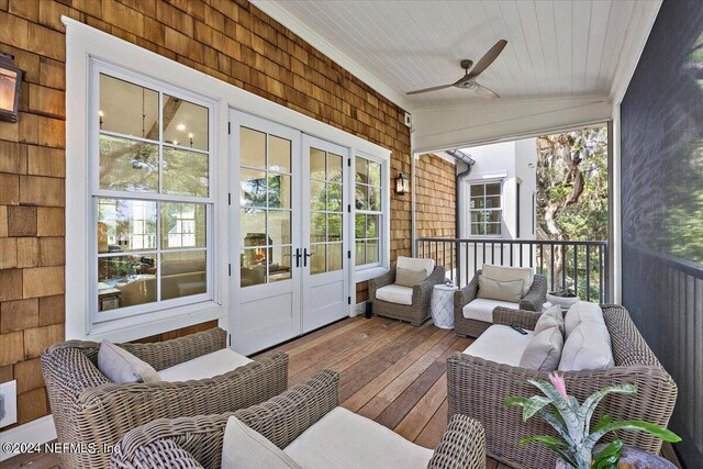 sunroom / solarium featuring ceiling fan, vaulted ceiling, and french doors