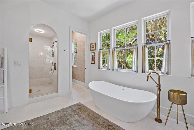 bathroom featuring shower with separate bathtub