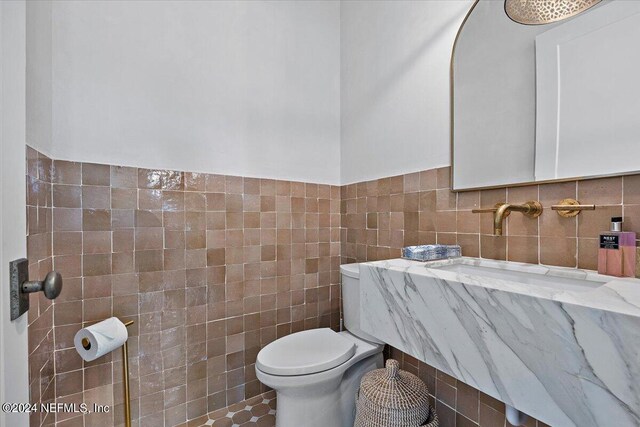 bathroom with tile walls, tile patterned flooring, and toilet