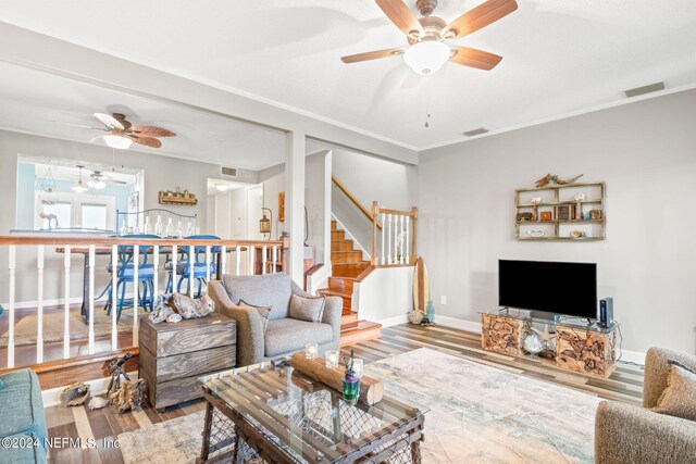 living room with ceiling fan, hardwood / wood-style flooring, and crown molding