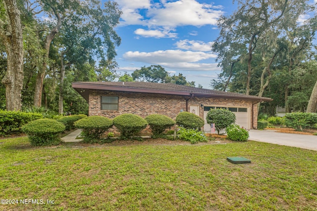 ranch-style house featuring a front yard and a garage