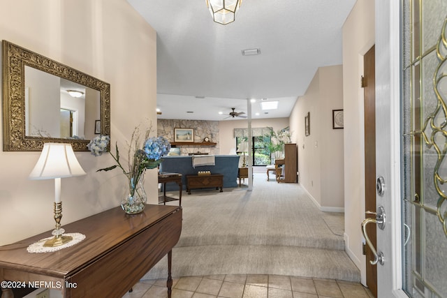 entrance foyer featuring a textured ceiling, ceiling fan, and light tile patterned flooring