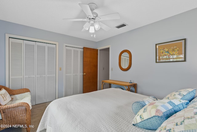 bedroom featuring ceiling fan, carpet, and multiple closets