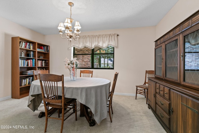 dining area featuring light colored carpet, a notable chandelier, and a textured ceiling