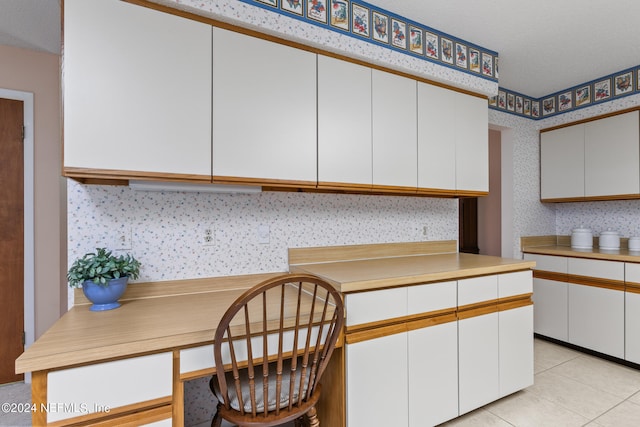 kitchen with light tile patterned floors and white cabinetry