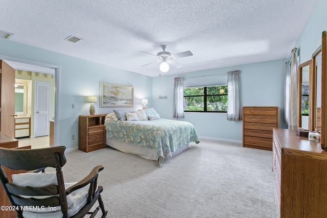 bedroom with light colored carpet, ceiling fan, and a textured ceiling