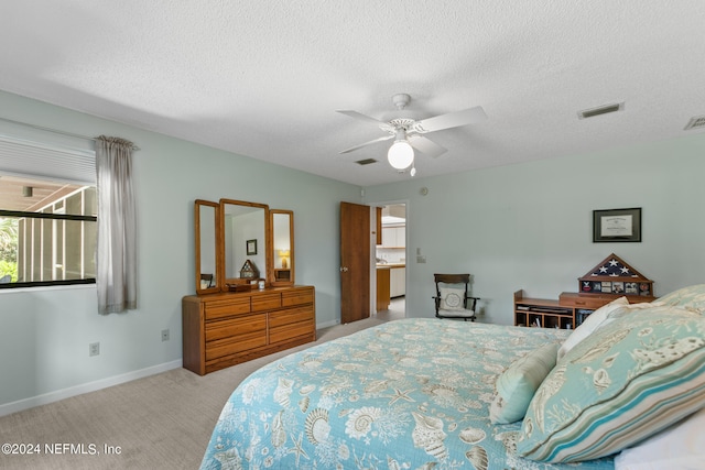 carpeted bedroom featuring a textured ceiling and ceiling fan