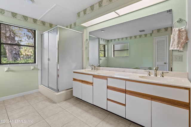 bathroom featuring a textured ceiling, vanity, a shower with shower door, and tile patterned floors