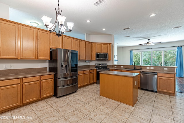 kitchen featuring a center island, ceiling fan with notable chandelier, appliances with stainless steel finishes, sink, and pendant lighting