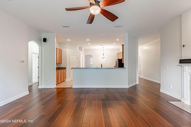 unfurnished living room with ceiling fan and dark hardwood / wood-style floors