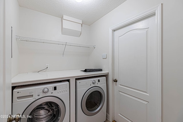 laundry room with washer and dryer and a textured ceiling