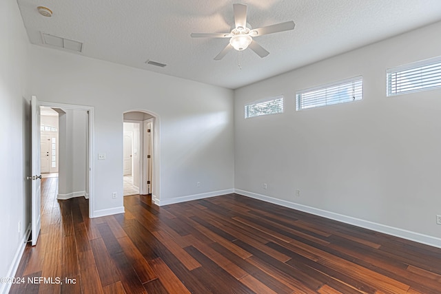 unfurnished bedroom with dark wood-type flooring, ceiling fan, and a textured ceiling