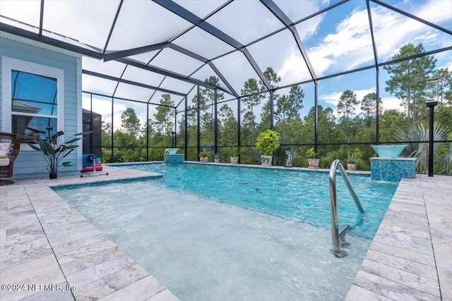 view of pool with pool water feature, a patio, and glass enclosure