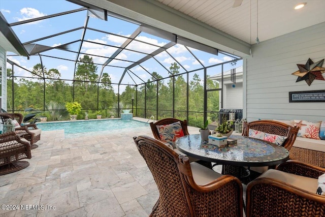 view of swimming pool with ceiling fan, a lanai, and a patio area