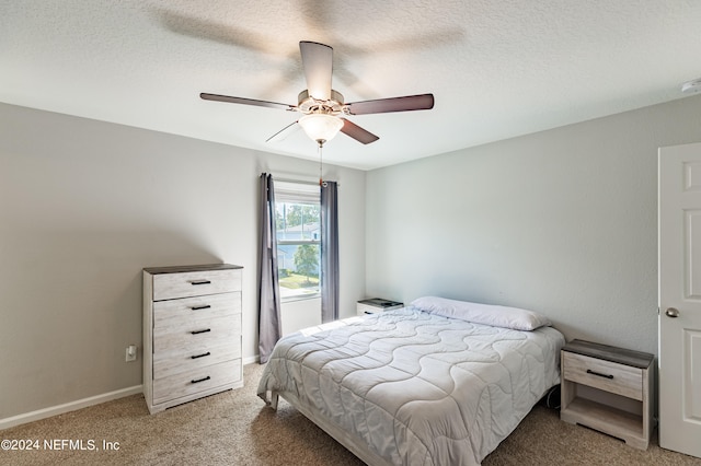 carpeted bedroom featuring a textured ceiling and ceiling fan