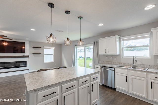 kitchen with decorative light fixtures, dark hardwood / wood-style flooring, stainless steel dishwasher, a center island, and white cabinetry