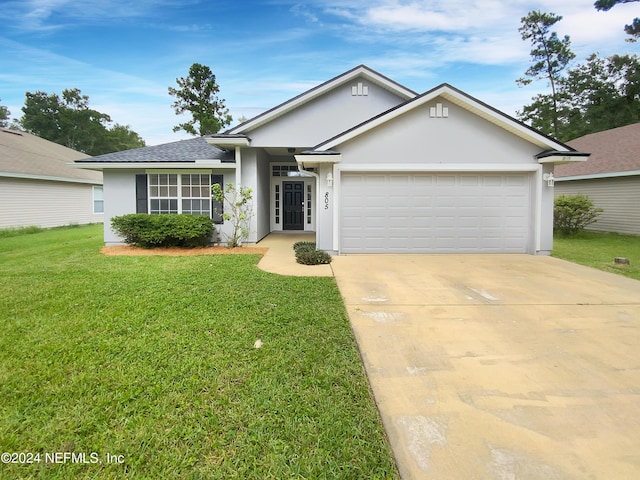 ranch-style house featuring driveway, an attached garage, a front yard, and stucco siding