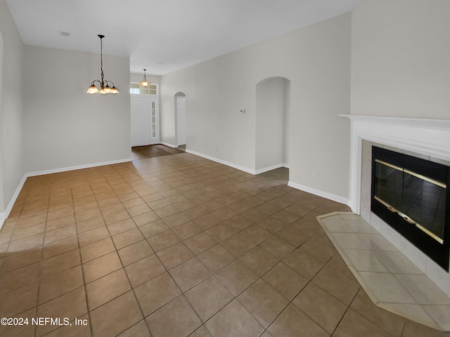 unfurnished living room with a notable chandelier and light tile patterned floors