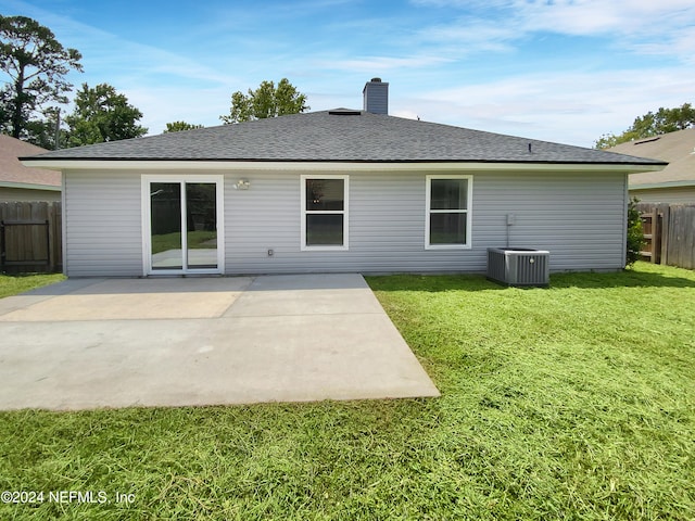 rear view of house featuring central AC unit, a patio, and a lawn