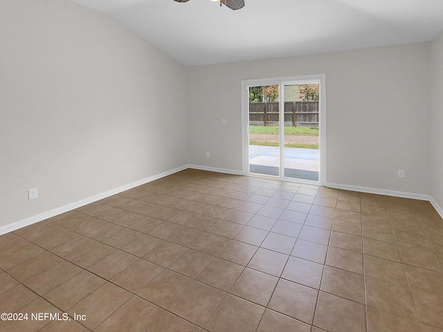 spare room with ceiling fan, light tile patterned floors, and vaulted ceiling