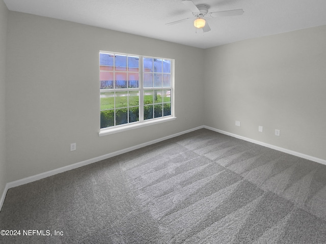 carpeted spare room featuring ceiling fan