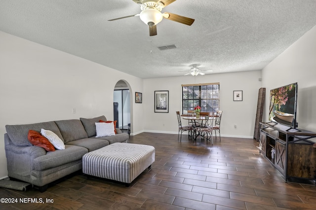 living room with ceiling fan and a textured ceiling