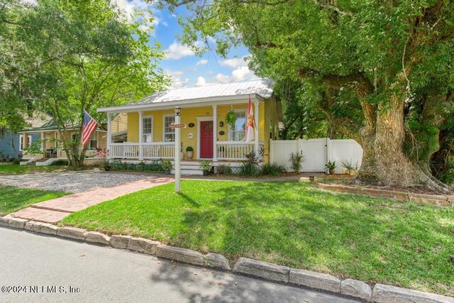 bungalow with covered porch and a front yard