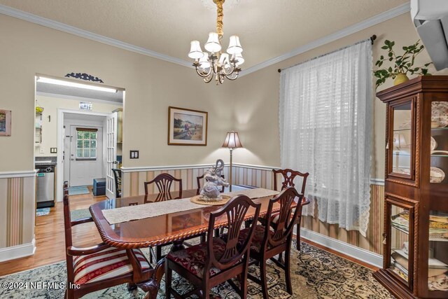 dining space featuring crown molding, a notable chandelier, and light hardwood / wood-style floors