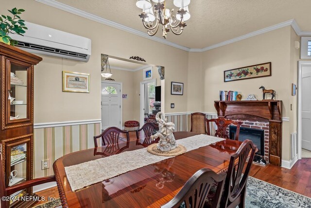 dining space featuring crown molding, dark wood-type flooring, an AC wall unit, a brick fireplace, and a chandelier