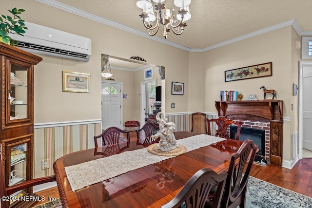 dining area with a notable chandelier, an AC wall unit, ornamental molding, a textured ceiling, and wood finished floors