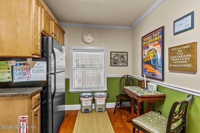 kitchen with crown molding, brown cabinetry, dark wood-style floors, and baseboards