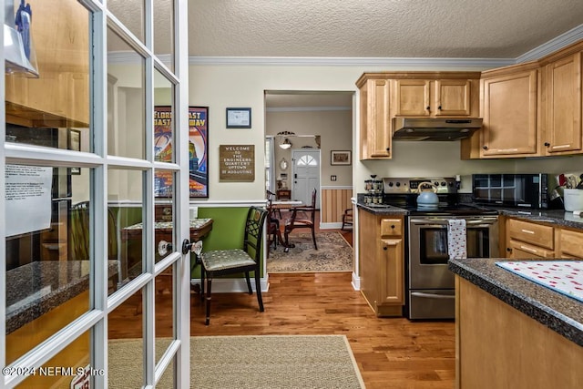 kitchen with under cabinet range hood, dark countertops, wood finished floors, stainless steel electric range, and black microwave