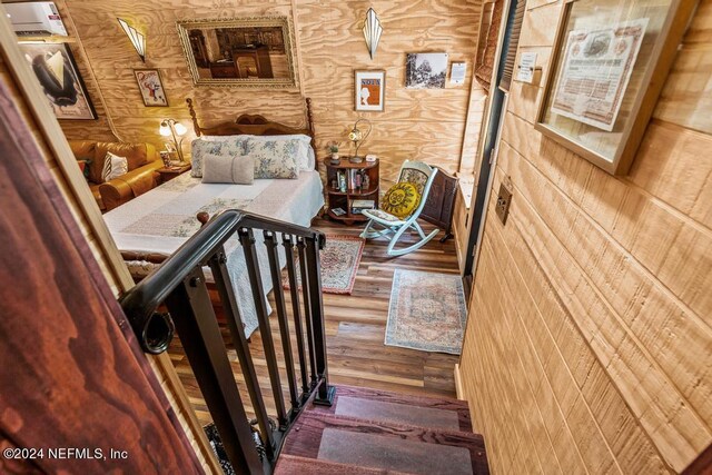 stairway with wood-type flooring and wooden walls