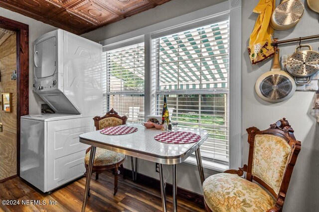 dining space featuring stacked washer and clothes dryer and dark hardwood / wood-style flooring