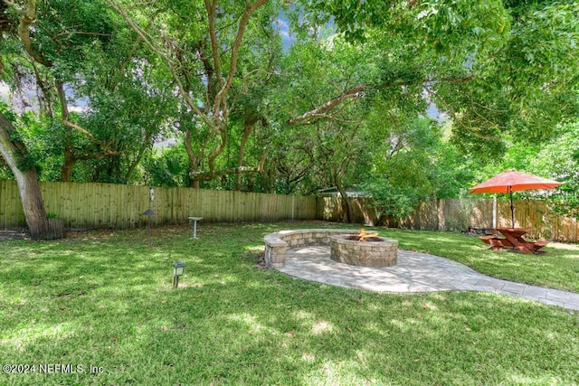 view of yard featuring a patio, an outdoor fire pit, and a fenced backyard