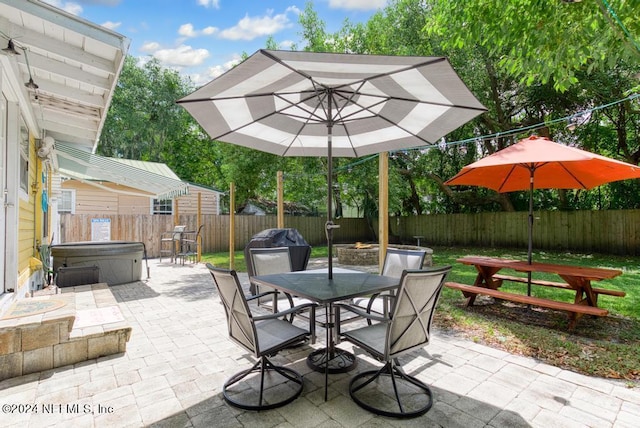 view of patio / terrace featuring a hot tub, outdoor dining area, and a fenced backyard