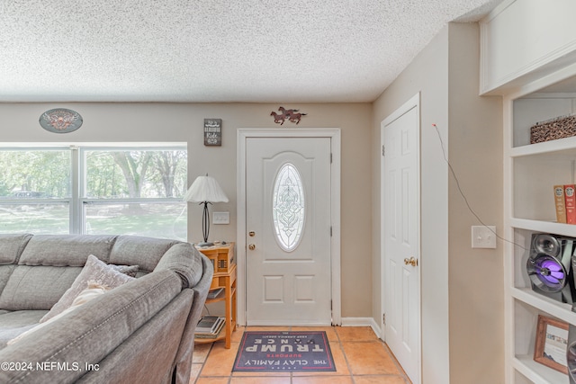 foyer entrance featuring light tile patterned floors and a textured ceiling