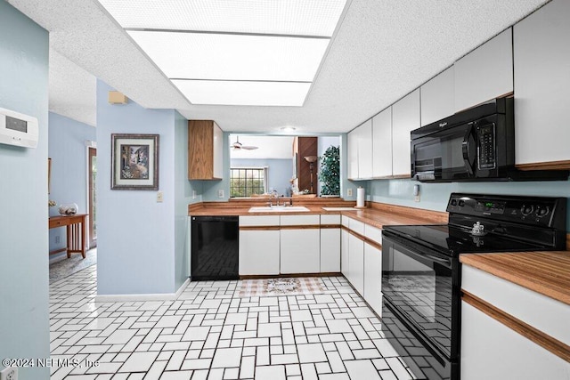 kitchen featuring sink, white cabinets, a textured ceiling, and black appliances