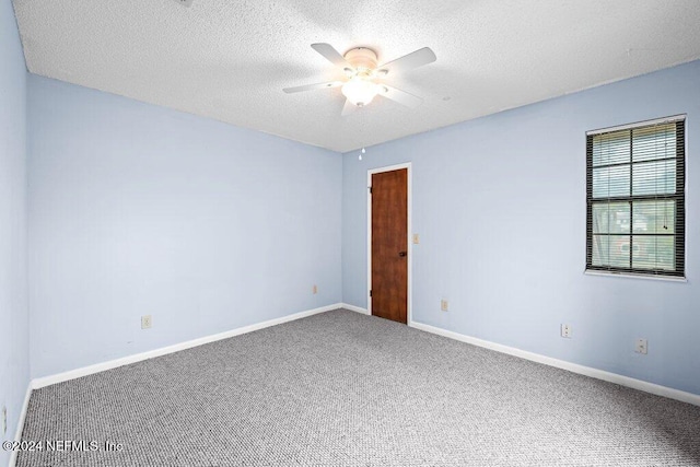 carpeted empty room with ceiling fan and a textured ceiling