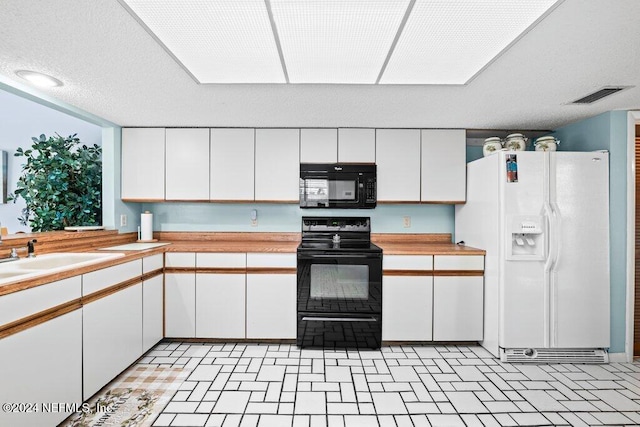 kitchen featuring sink, white cabinets, and black appliances