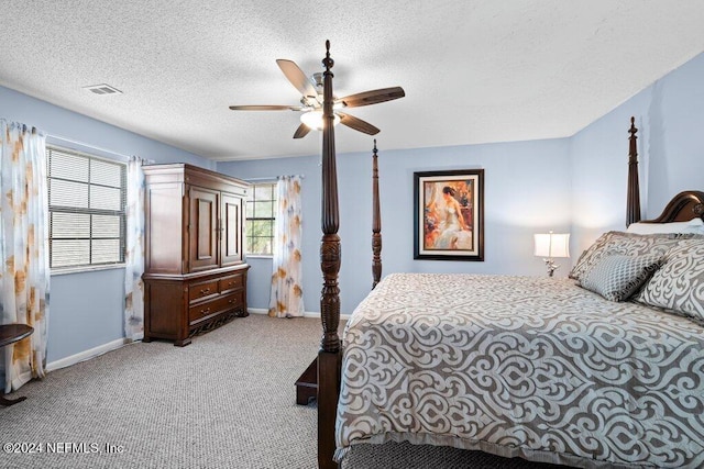 carpeted bedroom featuring ceiling fan and a textured ceiling