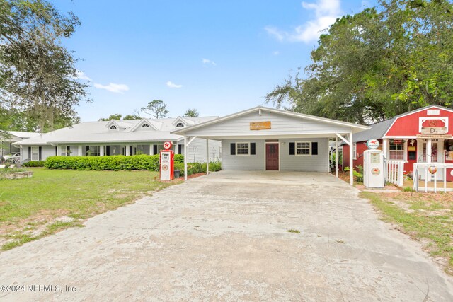 ranch-style house with an outbuilding, a carport, and a front yard