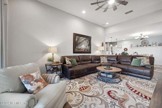 living room featuring ceiling fan with notable chandelier