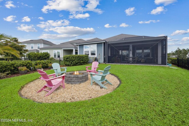 exterior space featuring a yard, glass enclosure, a patio, and a fire pit