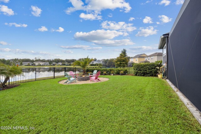 view of yard featuring a fire pit and a water view