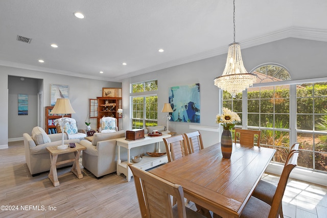 dining space with ornamental molding, light hardwood / wood-style floors, a notable chandelier, and vaulted ceiling