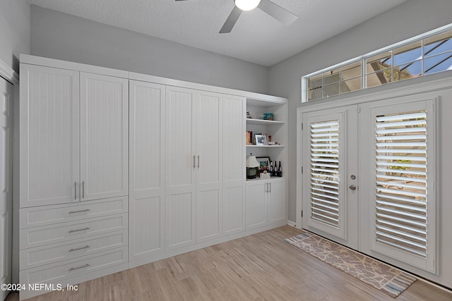 entryway featuring light wood-type flooring, a textured ceiling, and ceiling fan