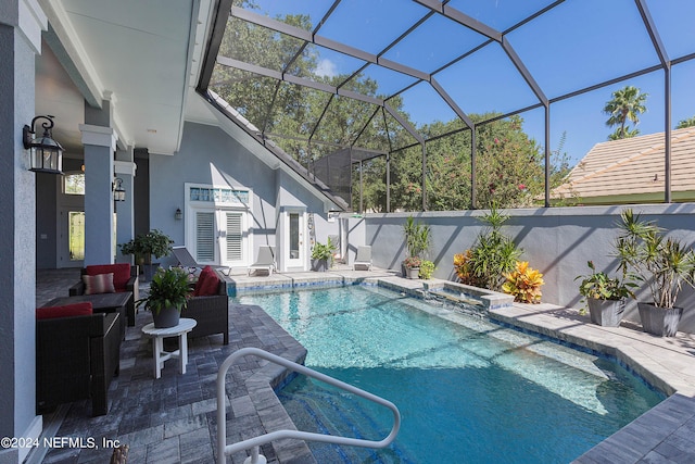 view of pool featuring a lanai, a pool with connected hot tub, and a patio